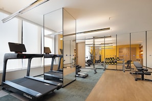 A gym with treadmills, weights, and exercise equipment.