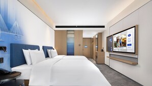 A modern hotel room with a large bed, a TV mounted on the wall, and a view of the cityscape. - Hampton by Hilton Ningbo Xiangshan  (Ningbo)