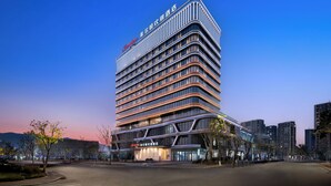 A multi-story hotel with a modern design, featuring a prominent signage at the top and a well-lit facade. - Hampton by Hilton Ningbo Xiangshan  (Ningbo)