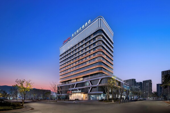 A multi-story hotel with a modern design, featuring a prominent signage at the top and a well-lit facade.