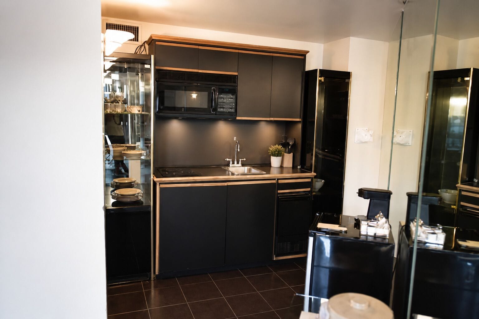 A compact kitchen with a built-in microwave, a sink, and a small countertop area.