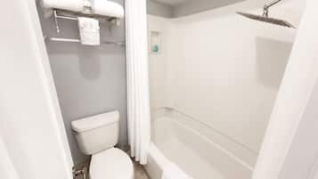 Um banheiro com vaso sanitário, chuveiro e porta-toalhas.