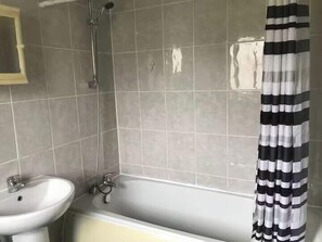 A bathroom with a bathtub, a sink, and a shower. - Bungalow Sleeps 3 with Parking and Garden (Manchester)