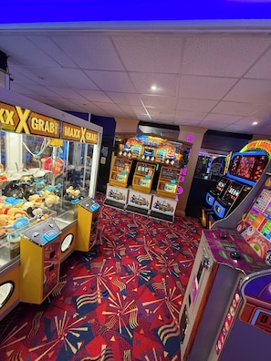 Una sala con máquinas de garra, juegos de arcade y peluches.