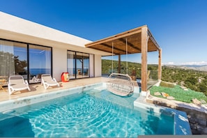 A modern outdoor pool area with clear blue water, a wooden pergola, and a view of the landscape. - Mediterran Infinity Villa Pool Seaview (Shengjin)