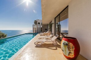 A poolside area with lounge chairs and a decorative vase. - Mediterran Infinity Villa Pool Seaview (Shengjin)