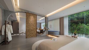 Habitación de hotel moderna con una cama grande, un escritorio y vistas a zonas verdes.