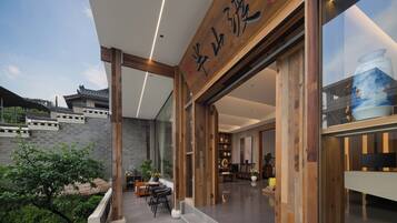 A modern building with large wooden beams, a traditional-style roof, and a spacious interior with a dining area and shelves.