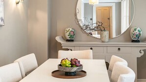 A dining area with a table, chairs, a chandelier, and a decorative mirror. - 5-bed Chelsea Home Next To Kings Road (London)