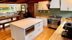 Une cuisine moderne dotée d’un îlot central, d’un four encastré et d’une cuisinière.