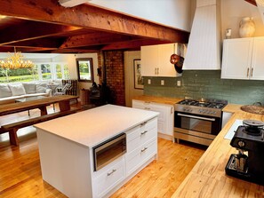 Una cocina moderna con una isla central, horno empotrado y estufa.