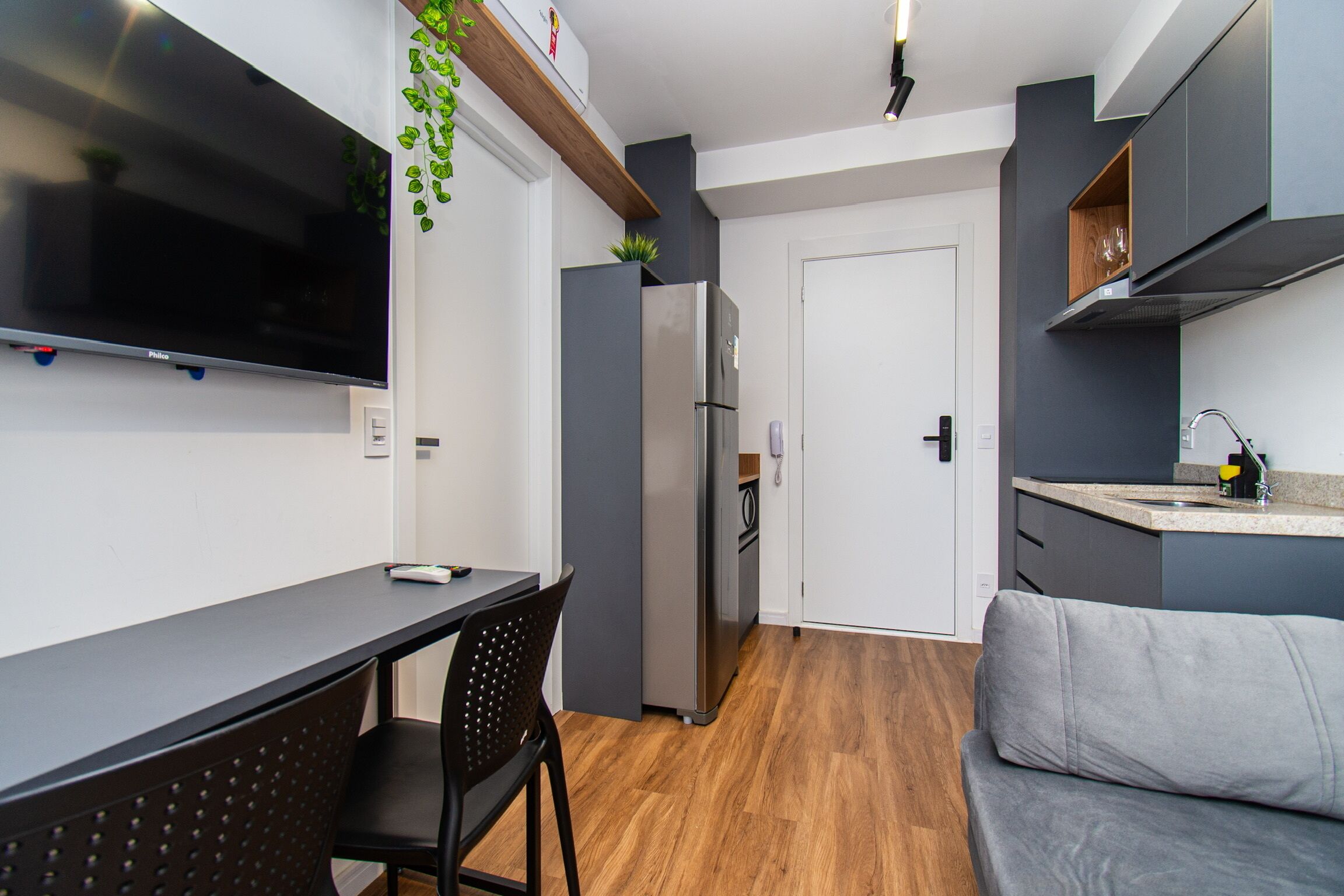 Una cucina moderna con TV a schermo piatto, forno integrato e zona pranzo con tavolo e sedie.