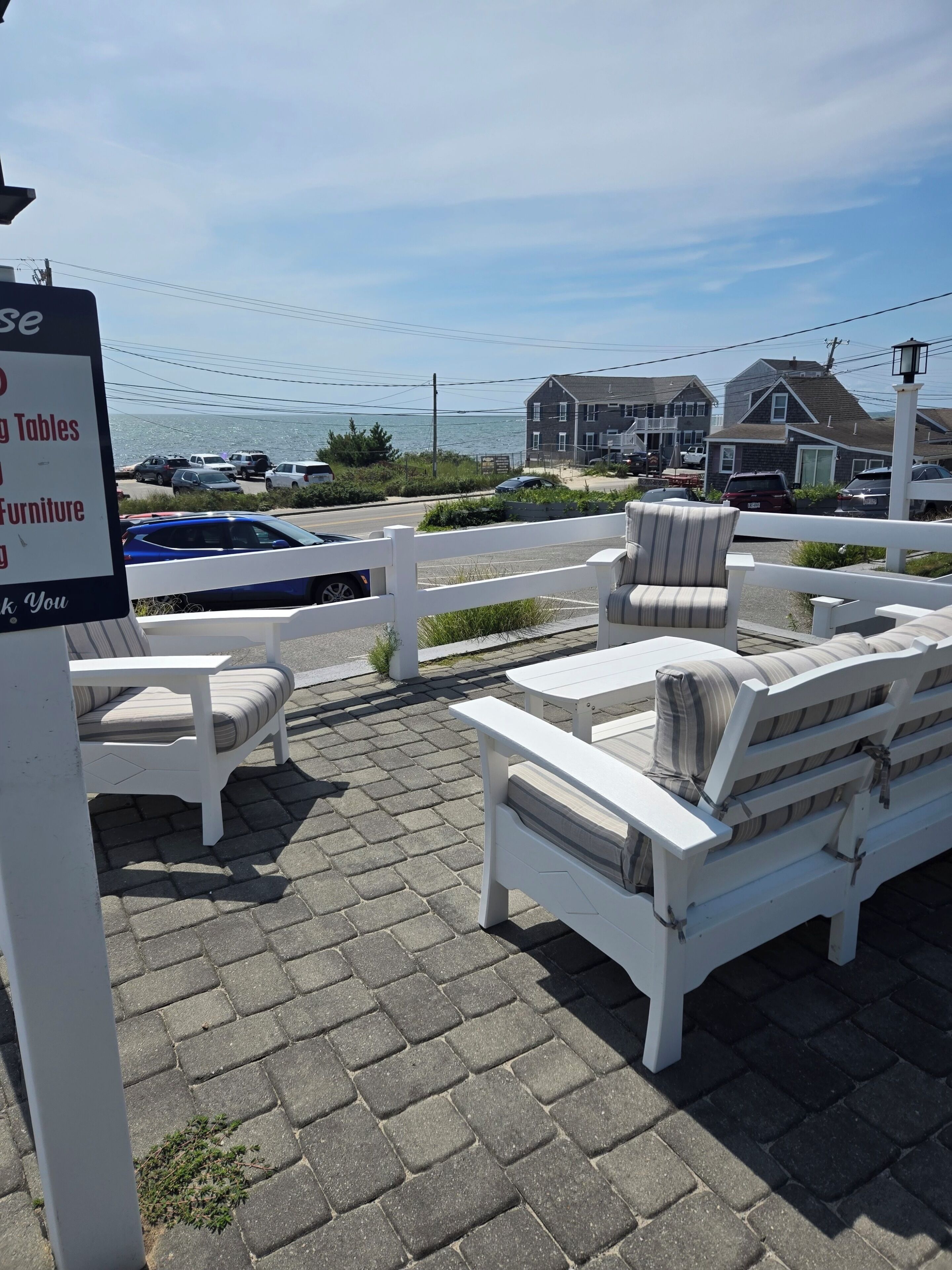 Outdoor furniture with a view of the sea and houses in the background.