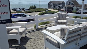 Outdoor furniture with a view of the sea and houses in the background.