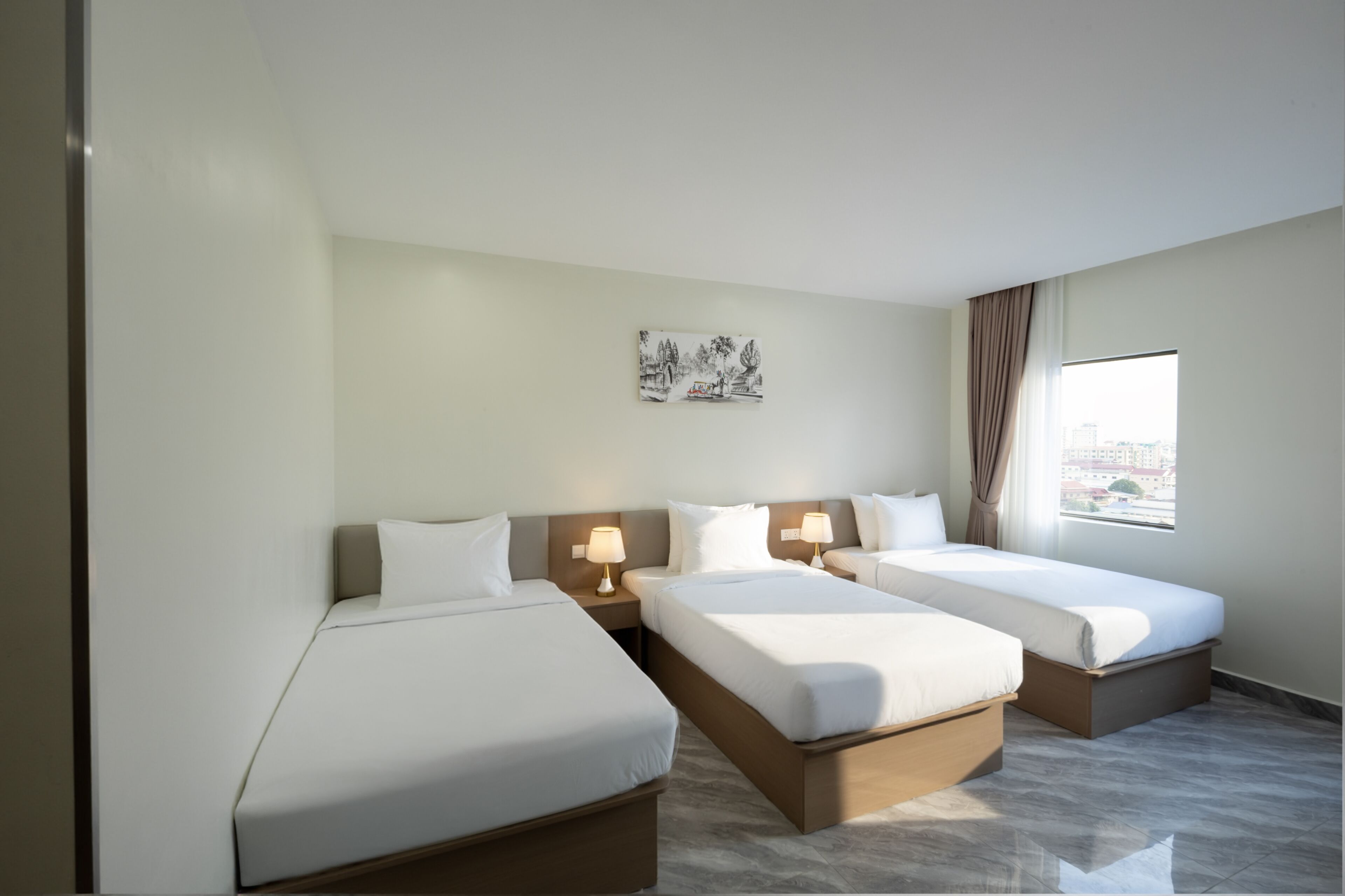 Habitación de hotel con dos camas individuales, una mesita, una lámpara y ventana con vistas.