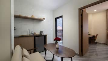 Una cocina moderna con horno empotrado, un comedor con mesa y sillas, y vista a un edificio.
