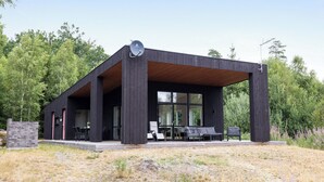 A modern building with a covered patio area, large windows, and a satellite dish. - Paradiset 2 by Interhome (Holmsjö)