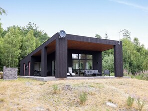 A modern building with a covered patio area, large windows, and a satellite dish. - Paradiset 2 by Interhome (Holmsjö)