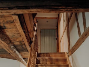 A wooden staircase leading to a room with a door.