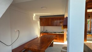 Una cocina moderna con armarios de madera, un banco empotrado y una mesa de comedor.