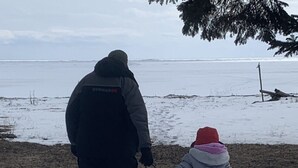 A person and a child walking on a snowy path with a sled. - Granny`s Cabin on Sandy Lake Huron (Au Gres)
