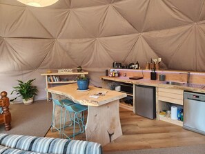 Une cuisine compacte comprenant un coin bar, un évier et un réfrigérateur.