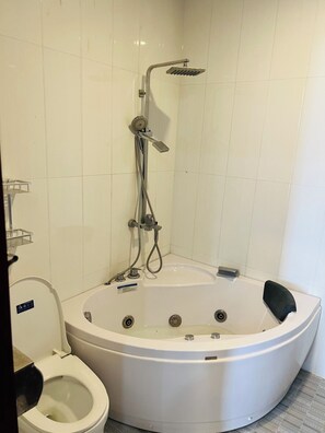 A bathroom with a bathtub, toilet, and shower. - Dong Thanh Hotel (Bac Ninh)
