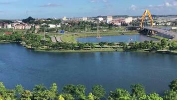 Un río con un puente, un parque y edificios al fondo.
