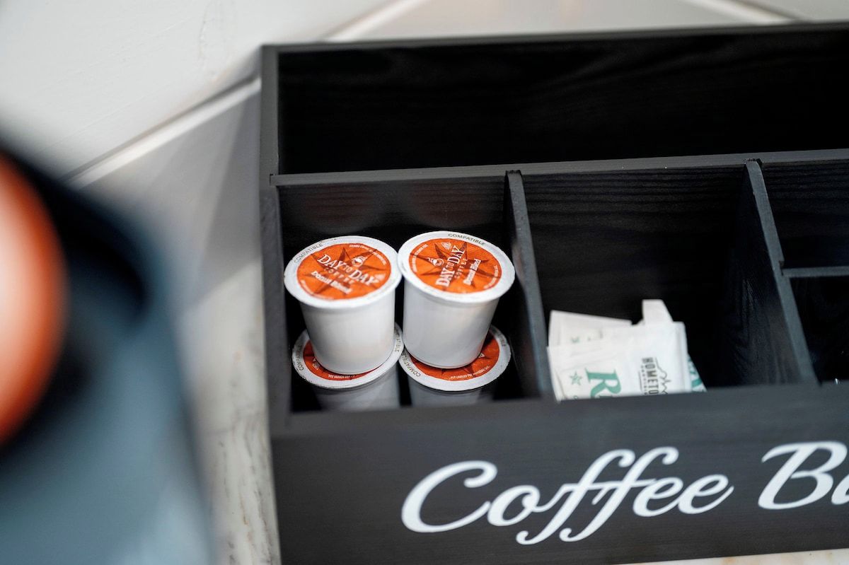 Caja para café con divisiones que contienen cápsulas de café y un artículo de la marca.