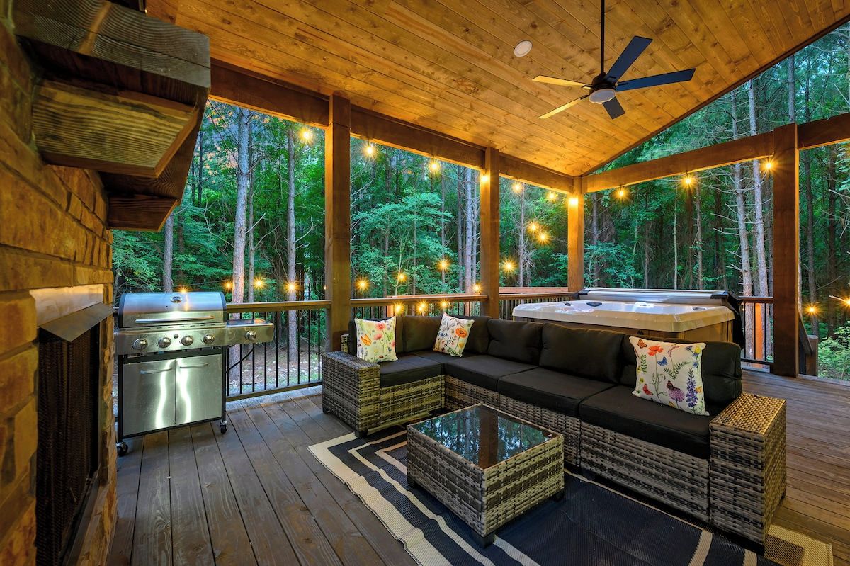 Un espace extérieur abrité comprenant un barbecue, des sièges et un jacuzzi.