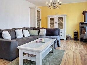 Un salon comprenant un canapé, une table basse, un meuble et une cheminée.