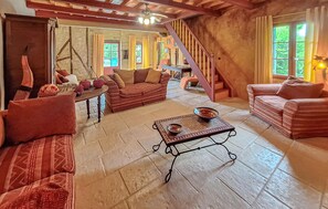 Ein gemütliches Wohnzimmer mit einer Sofagarnitur, einem Couchtisch und einer Treppe.