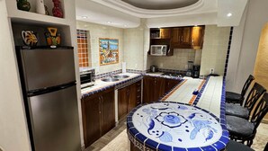 A modern kitchen with a central island, wooden cabinets, and a herringbone floor pattern. - Velas Vallarta Beach Front Resort (Puerto Vallarta)
