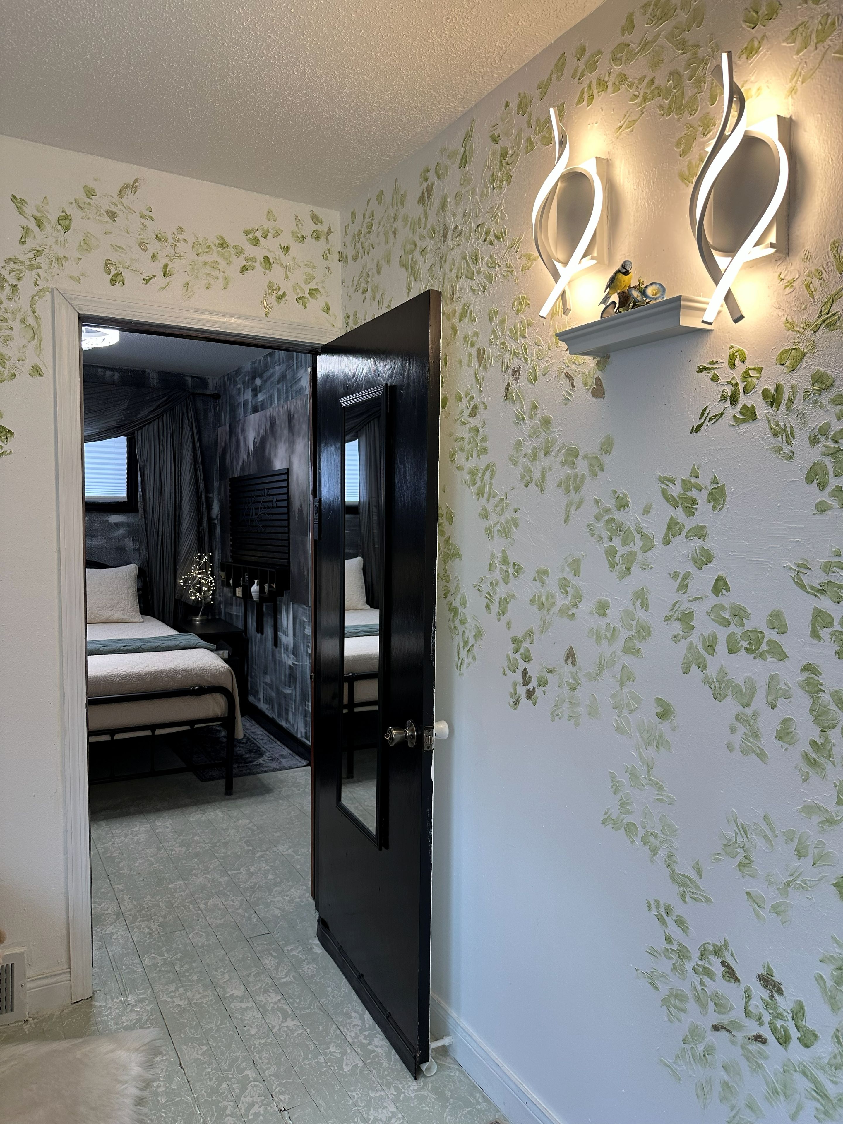 Ein Schlafzimmer mit Bett, Nachttisch, Kommode und einer Tür zu einem anderen Raum.