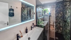 A modern bathroom with a long vanity, multiple mirrors, and a glass shower enclosure. - Belle maison rénovée (Dax)