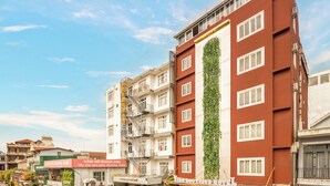 A multi-story hotel with a vertical garden on the facade, a staircase leading to the entrance, and a sign indicating the hotel name. - vina boutique hotel (Hue)