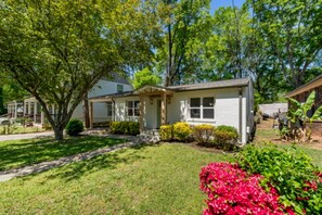 A single-story house with a front porch, a small front yard, and a garage.