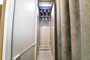 An elevator with a metallic finish, a vent on the wall, and a handrail on the left side. - Ayana Hotel & Resort (Mokpo)