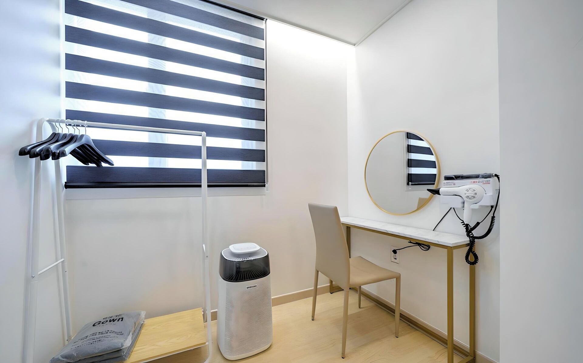 Un baño moderno con secador de pelo, espejo y tendedero.