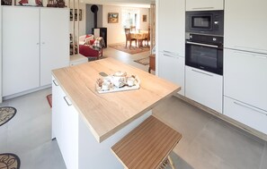 A modern kitchen with white cabinets, a wooden countertop, and a built-in oven. - 2 bedroom amazing apartment in Névez (Névez)