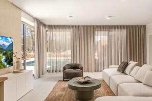 A modern living room with a sofa, a coffee table, and a TV on a stand. - Nareo Villa Collection - Villa Eora, Labin, Croatia (Labin)