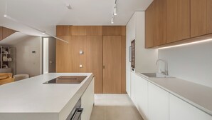 A modern kitchen with wooden cabinets, a white countertop, and built-in appliances. - Nareo Villa Collection - Villa Nara, Labin, Croatia (Labin)