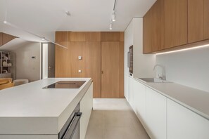 A modern kitchen with wooden cabinets, a white countertop, and built-in appliances. - Nareo Villa Collection - Villa Nara, Labin, Croatia (Labin)