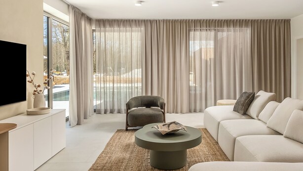 A modern living room with a sofa, a round coffee table, a TV, and a chair. - Nareo Villa Collection - Villa Nara, Labin, Croatia (Labin)
