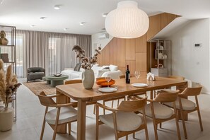 A modern dining area with a wooden table, chairs, and a large pendant light. - Nareo Villa Collection - Villa Arda, Labin, Croatia (Labin)