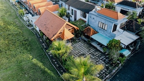 A residential area with houses, a paved courtyard, and a grassy area. - Bonito Suite Villa (Ubud)