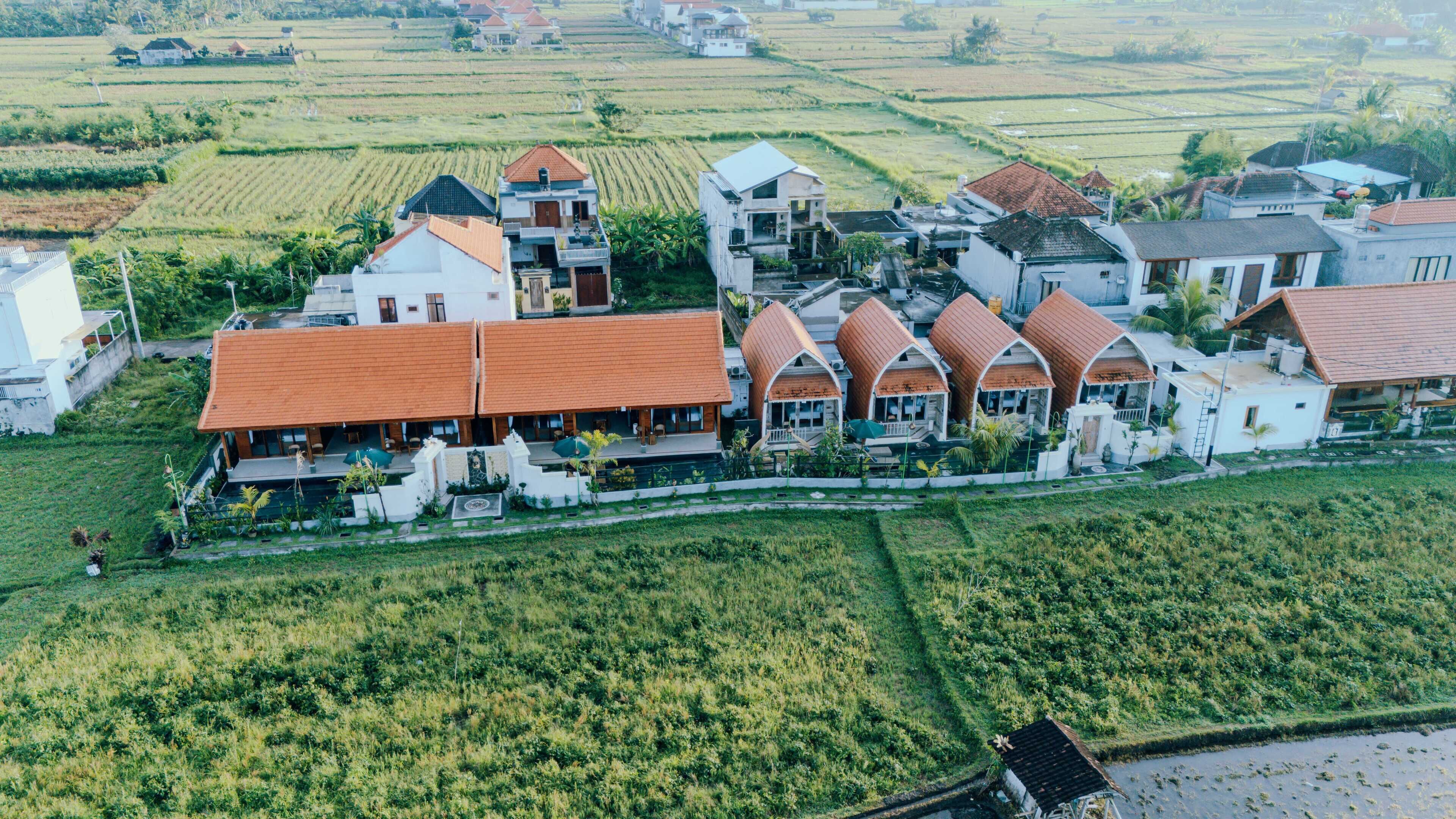 A rural village with terraced fields and traditional houses with red roofs.