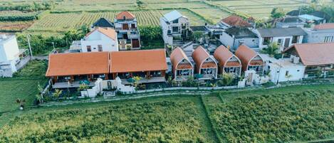 A rural village with terraced fields and traditional houses with red roofs.