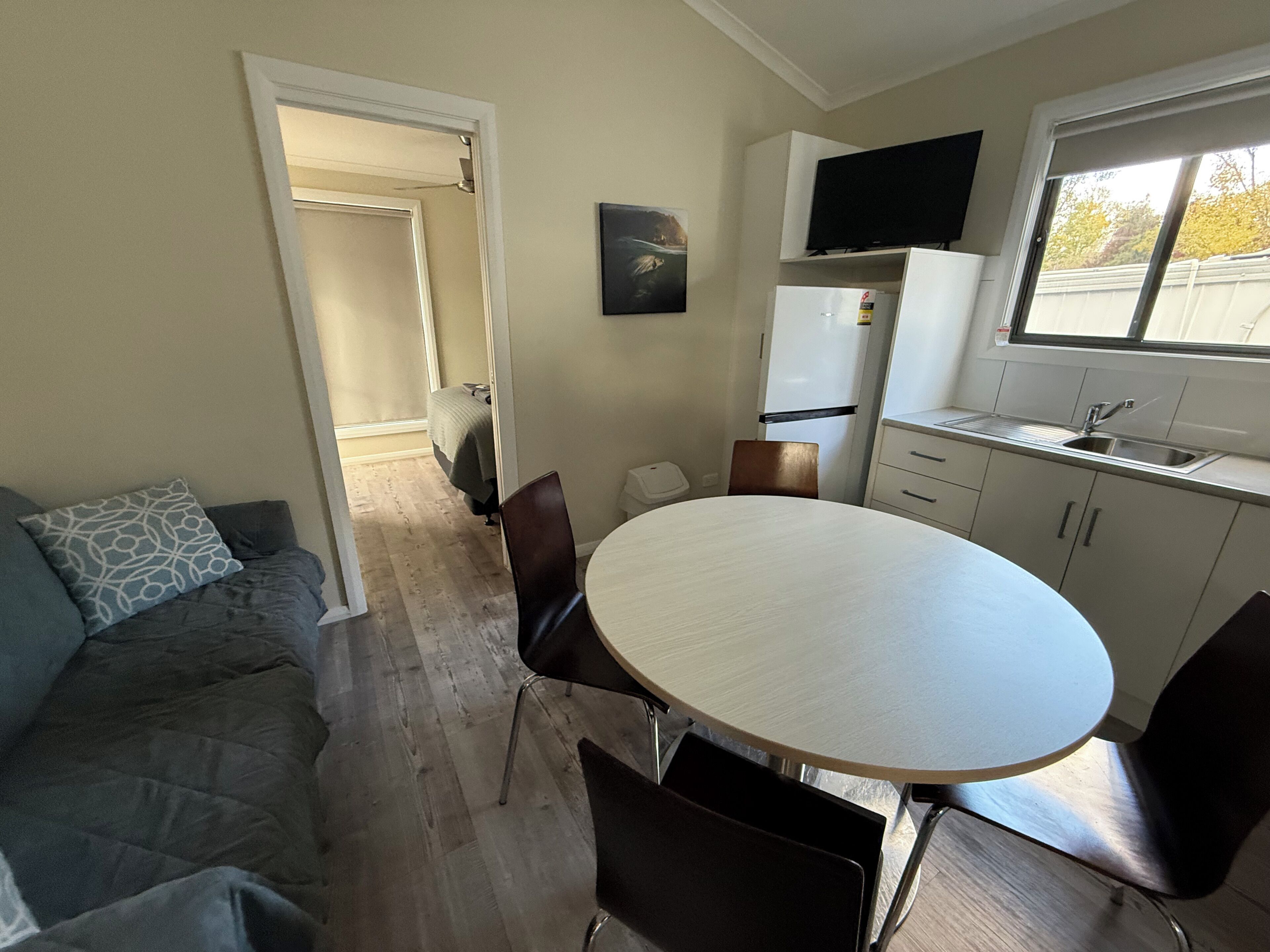 A compact living space with a kitchenette, a dining area, and a sofa.