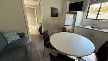 A compact living space with a kitchenette, a dining area, and a sofa.